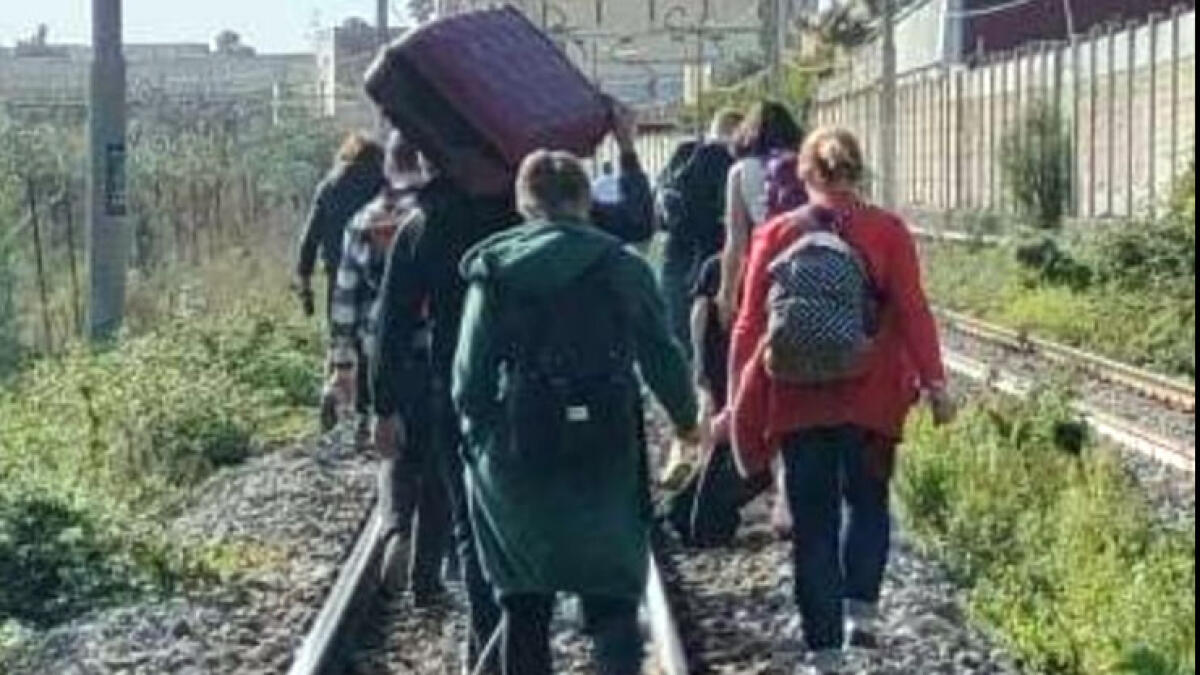 Guasto al treno Circum, turisti a piedi sui binari con il carico di bagagli - 